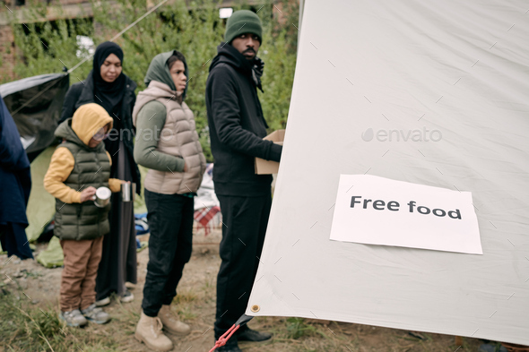 Queue of migrants standing in front of volunteering tent
