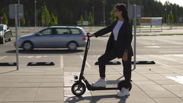 Epic Business Woman Standing with Electric Scooter at Parking Lot alt