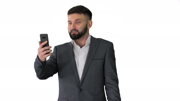 Businessman Making a Video Call with His Smartphone on White Background alt
