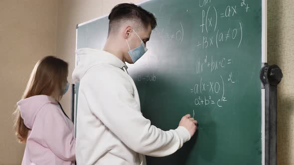 Group of Students with Face Mask Writing on the Board in the Classroom During Pandemic