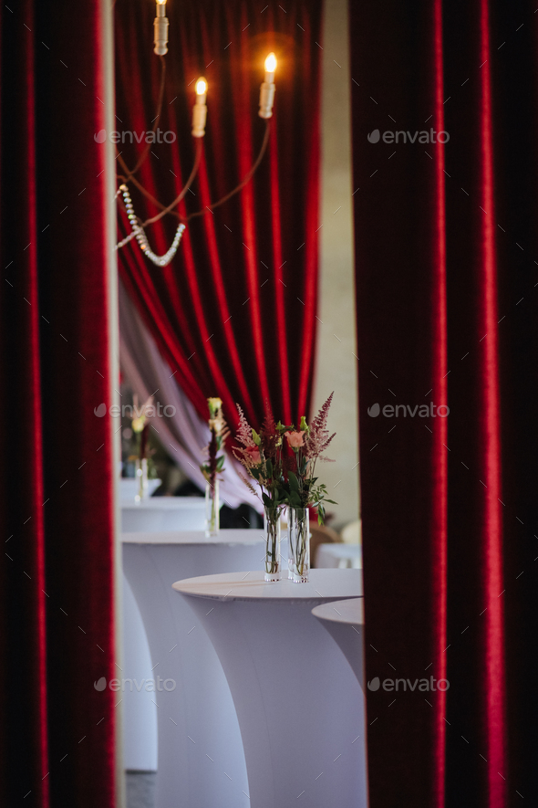 Interior of luxury banquet hall decorated with red curtains, candles ...