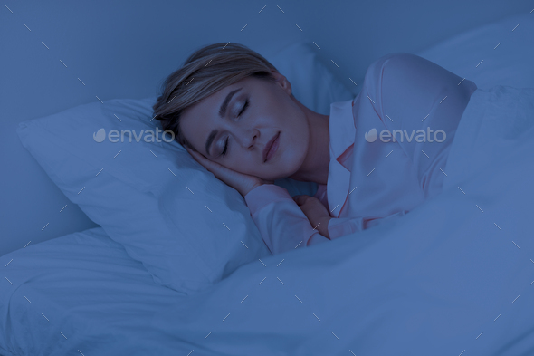 Beautiful mature woman sleeping well on pillow in the night