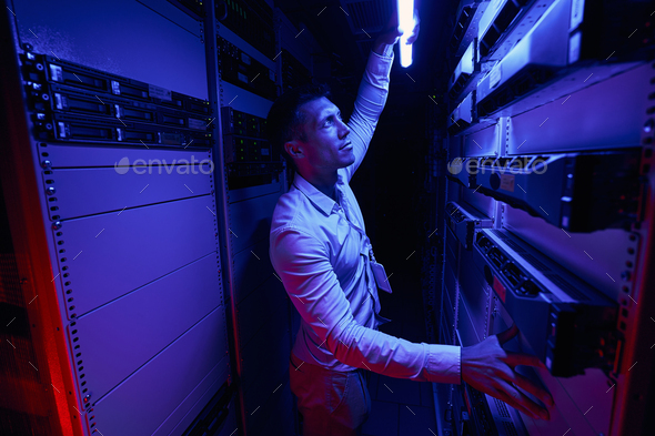 Data center employee monitoring cooling system in server room