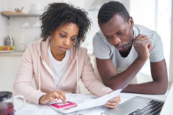 Stressed couple calculating expenses, managing family finances, sitting at kitchen table - Stock Photo - Images