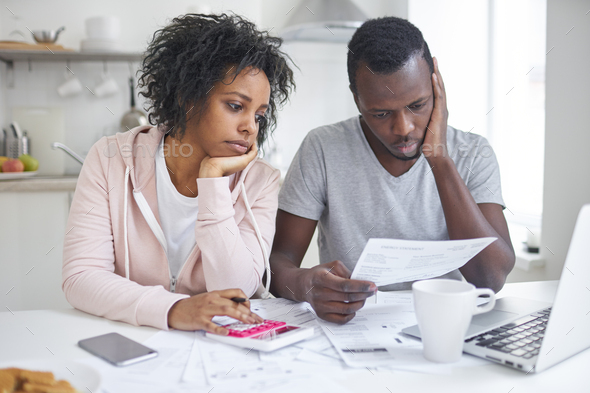 Unhappy couple having no money to pay off their debts, managing budget together - Stock Photo - Images