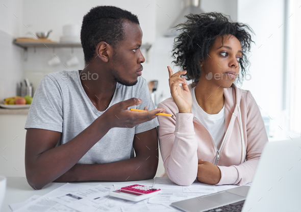 Angry family arguing about serious financial problems, sitting at kitchen table - Stock Photo - Images