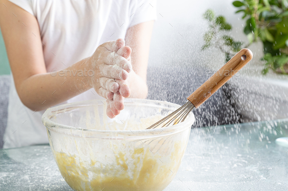Close-up of the upper body of a child clapping hands with flour stained hands