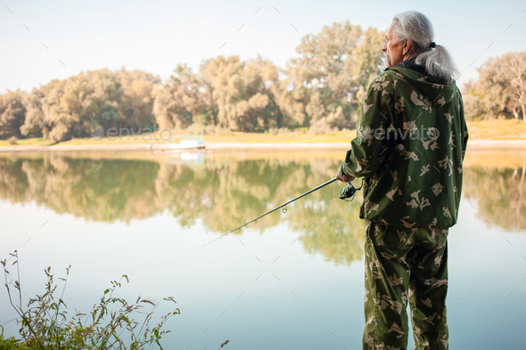 senior concept. pensioner fishes on the river in his spare time. A useful hobby, outdoor activities