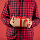 Man holding Christmas present, gift box in hands, isolated on red - PhotoDune Item for Sale