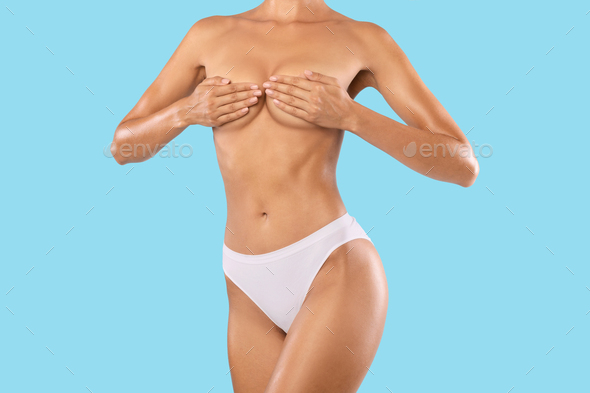 Very thin girl shows her skinny waist, covering his hands. Image is a  close-up Stock Photo
