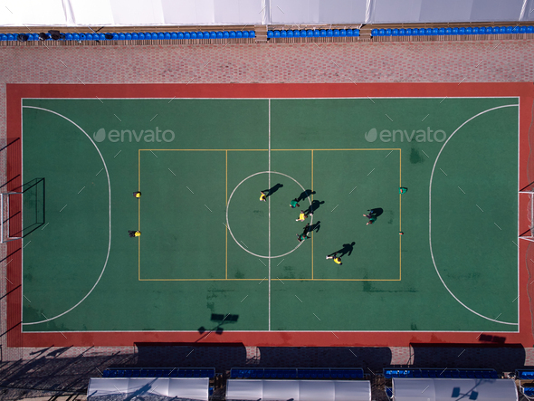 Aerial view from drone to soccer on mini field. People playing football