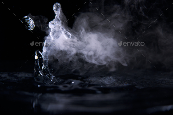 Boiling water splash with steam on black background closeup Stock Photo ...