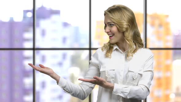 Young Emotional Woman in Formal Shirt Showing Something with Palms Up alt