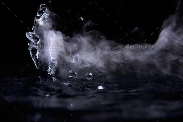 Boiling water splash with steam on black background closeup Stock Photo ...