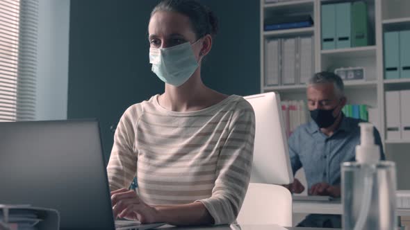 Business people working in the office and wearing face masks