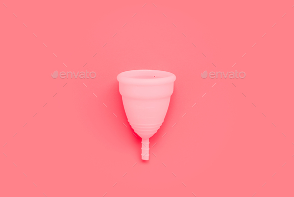 Pink menstrual cup on color background, female intimate hygiene period products, top view