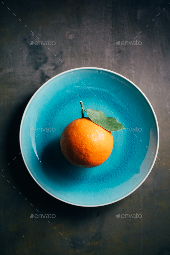 Fresh orange in a teal plate