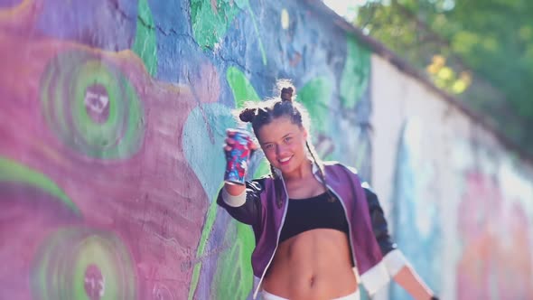 Beautiful Young Girl Spraying Colorful Aerosol Spray in the Air at Hot Summer Day. Daring Creativity alt