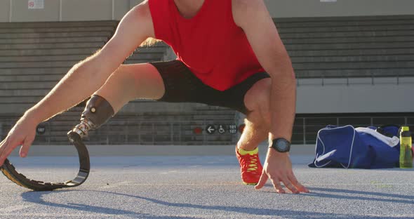Low section of caucasian disabled male athlete with running blade stretching alt