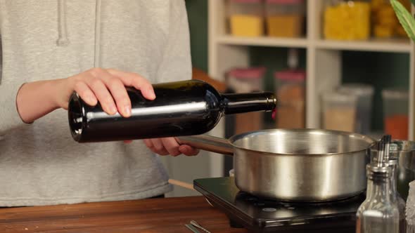 Woman Cooking Mulled Wine Gluhwein with Apples and Oranges Recipe alt