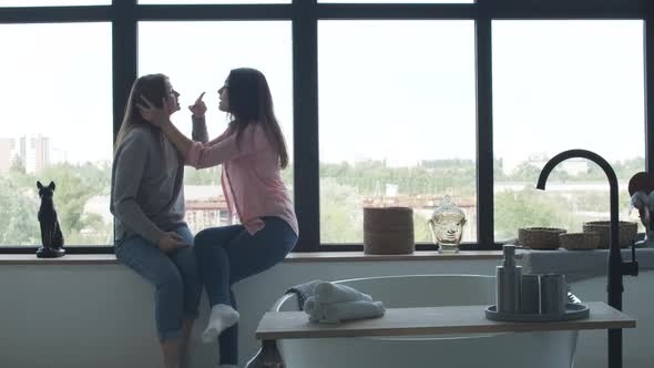 Lesbian Couple Quarrelling As Sitting on Windowsill. Beautiful Young Caucasian Gay Female Family alt