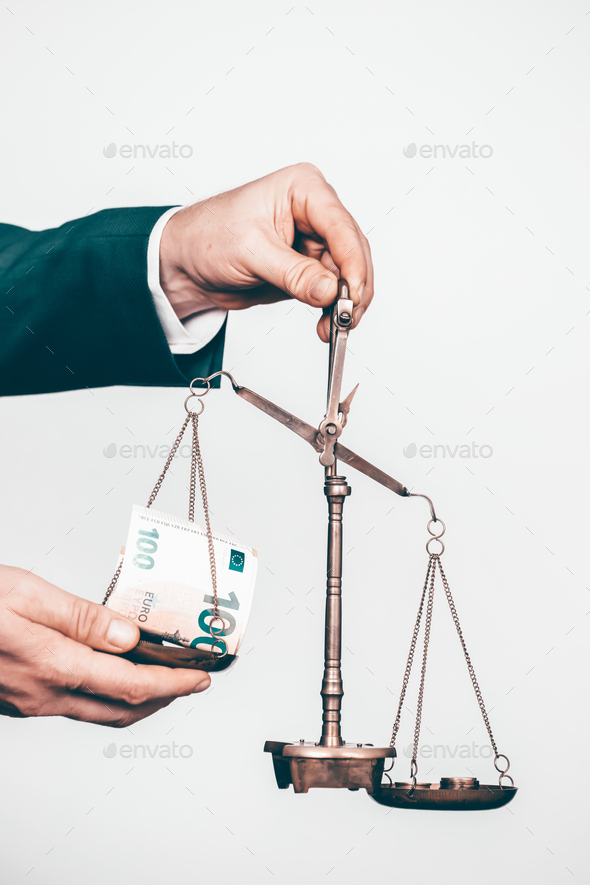 Money weighing on justice scale in business man hand. Payment balance and tax - Stock Photo - Images