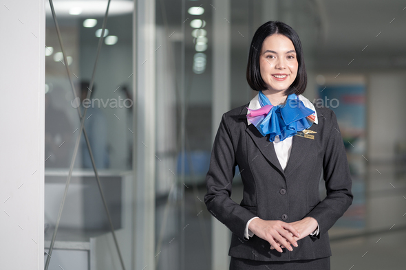 Beautiful Caucasian airline staff woman standing indoor in airport terminal building.
