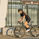 Side view of professional female cyclist in black cycling garment