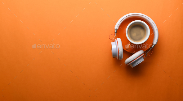 A cup of coffee, headphone and copy space on orange background. - Stock Photo - Images