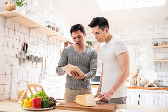 LGBT concept, Asian gay couple homosexual making food online broadcast in kitchen.