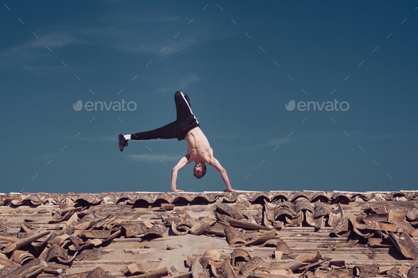 Man doing handstand on roof