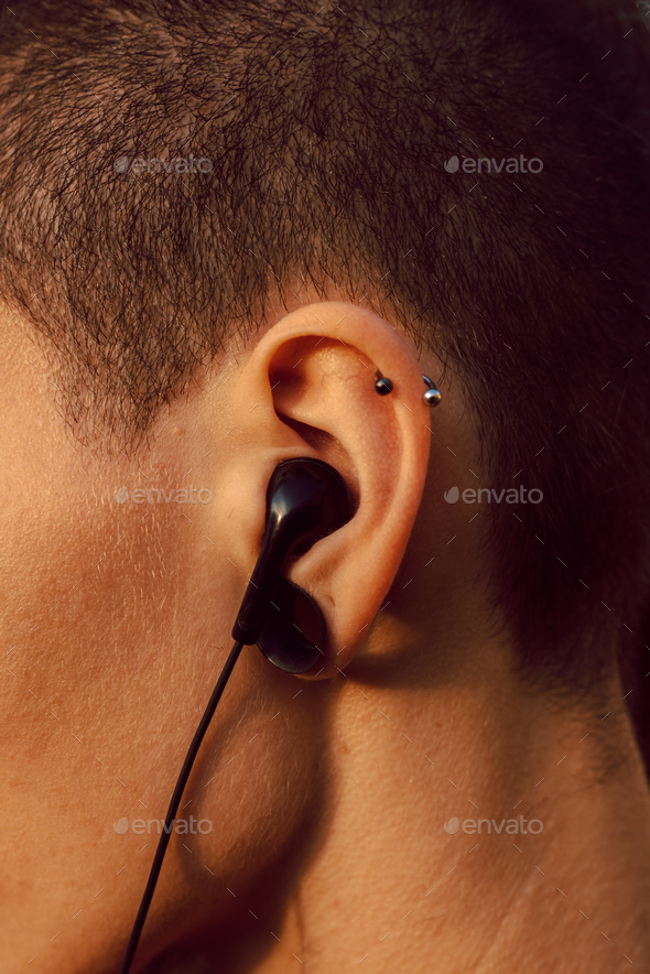 Person with piercing and earphones