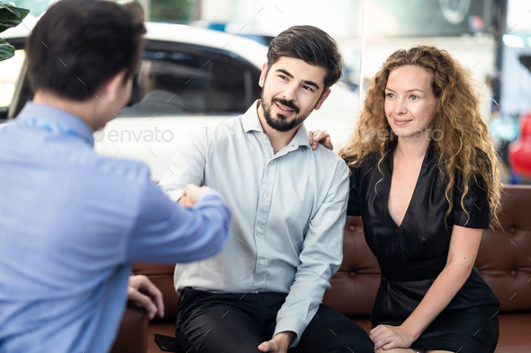 Caucasion couple getting great deal and complete agreement from car rental company officer.