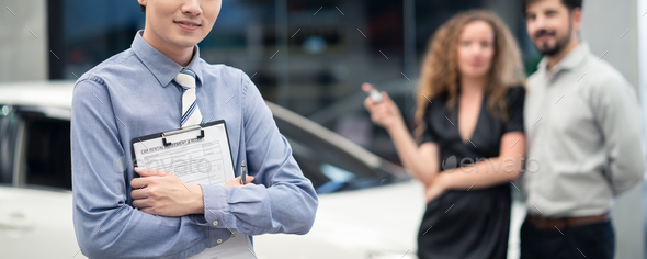 Asian officer male staff stands and hold rental agreement document. Car rental banner size concept