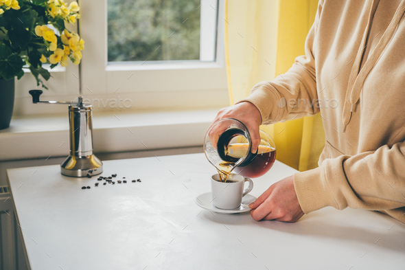 Unrecognisable woman pouring a coffee from glass coffee maker