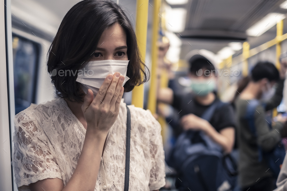 Asian woman wearing mask for prevent dusk pm 2.5 bad air pollution and coronavirus having headache - Stock Photo - Images