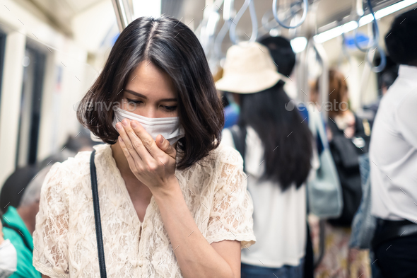Asian woman wearing mask for prevent dusk pm 2.5 bad air pollution and coronavirus and coughing - Stock Photo - Images