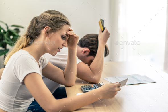 Caucasian young couple holding credit cards and bills worry about financial problem.