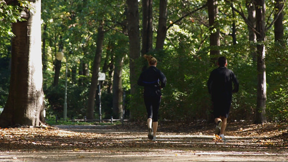 Man and Woman Running In Park