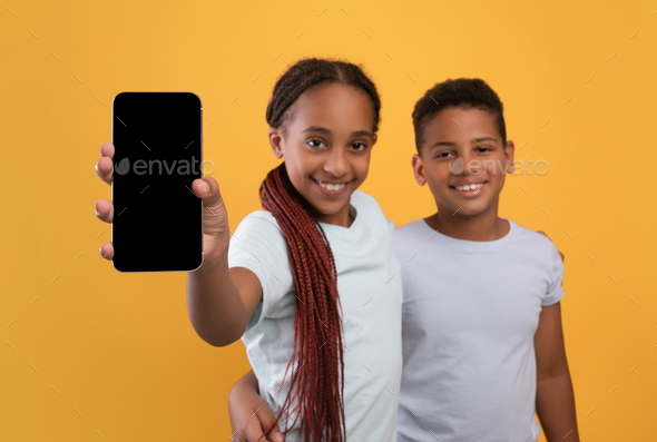 Cute african american kids showing smartphone with blank screen Stock ...