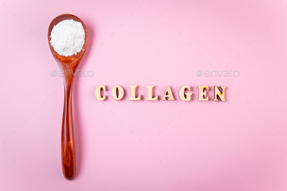 Natural bio supplement collagen powder in wooden spoon on a pink background.