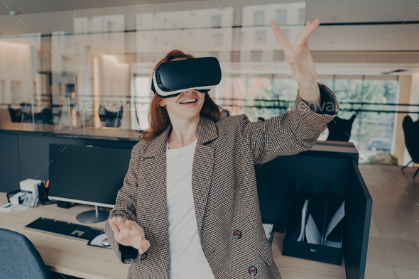 Female office worker using virtual reality headset to visualize and browse files at work