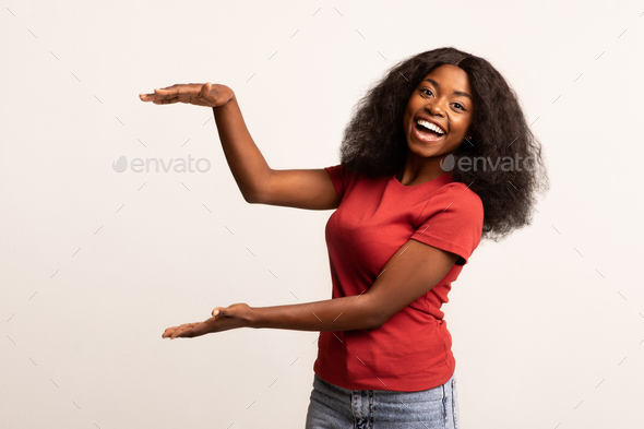 Cheerful African American Lady Holding Invisible Object With Her Hands - Stock Photo - Images