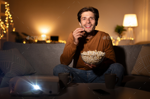 Side View Of Cheerful Man With Popcorn Watching Film In Cinema Stock Photo,  Picture and Royalty Free Image. Image 108185752.