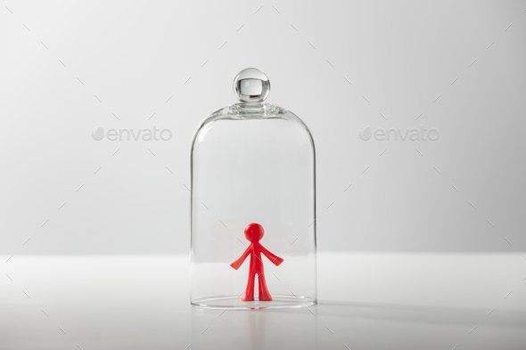 Plastic figure of a man under a glass cover - the concept of loneliness, depression, isolation