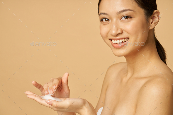 Beauty portrait of lovely young woman smiling at camera ready to apply gentle foam facial cleanser
