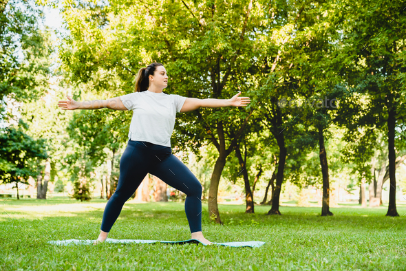 fat woman doing yoga in the park in the lotus position Stock Photo