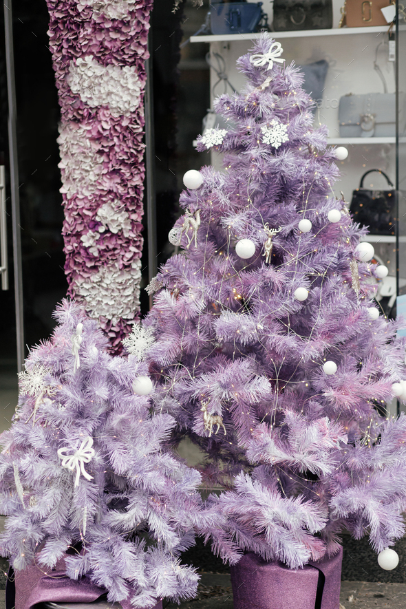 Modern purple christmas trees with ornaments and lights outdoor. Stylish  Christmas street decor Stock Photo by Sonyachny