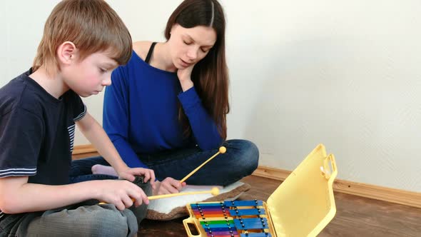 Playing Music Instrument. Boy Repeats for the Teacher Playing the Notes on the Xylophone.
