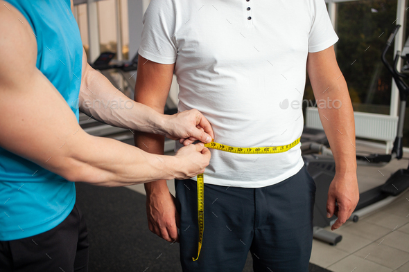 trainer measures with a centimeter tape, in inches, body size. Weight loss result, classes in the